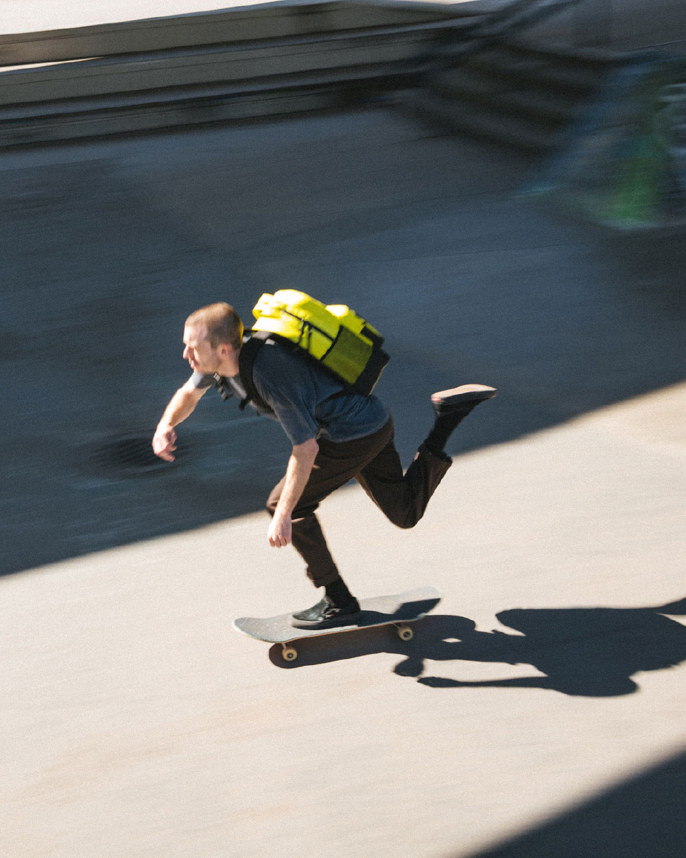 un homme en skateboard avec un sac à dos Miller isolant jaune sur