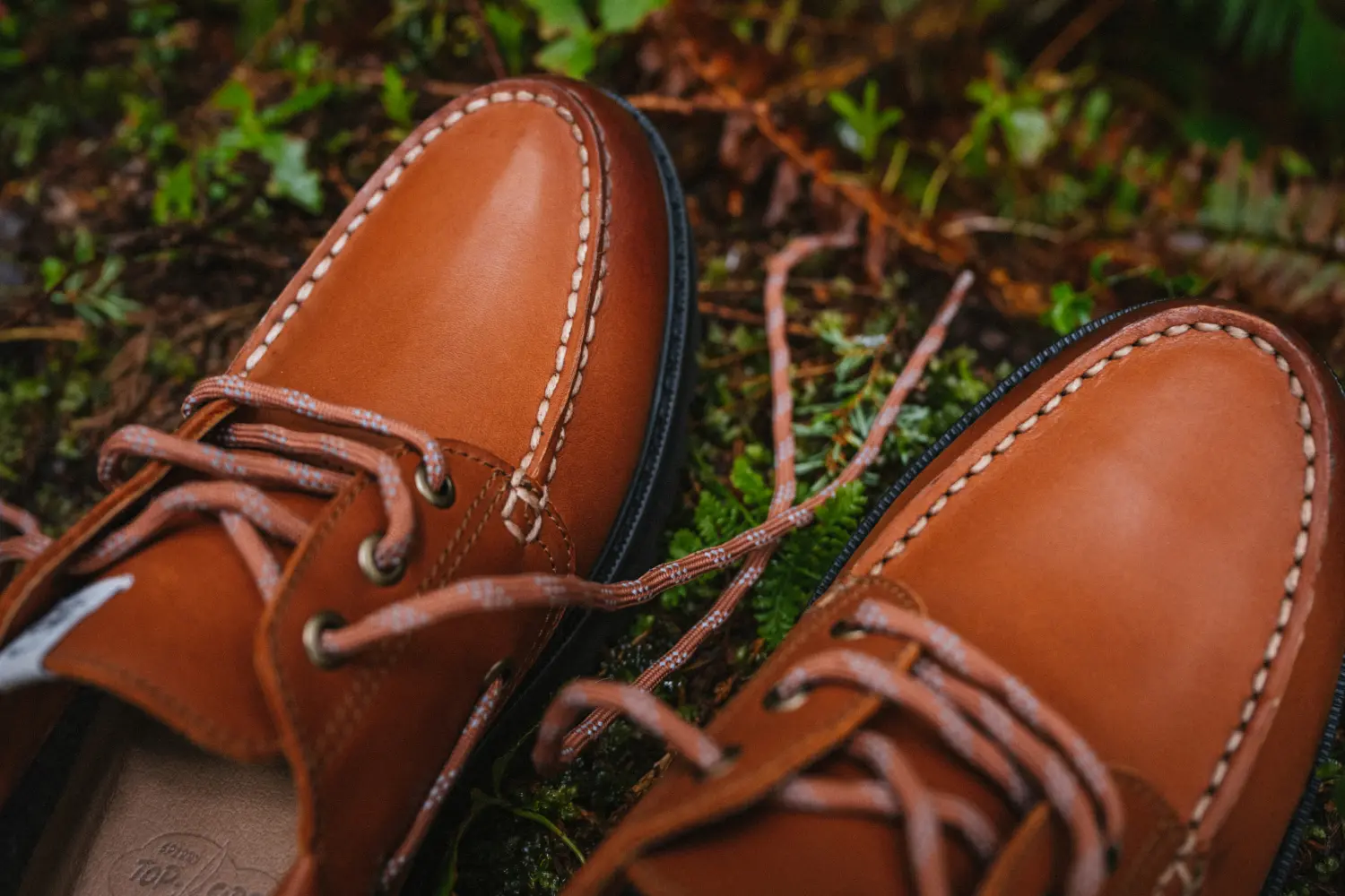 The Sperry x Herschel Authentic Original 3-Eye Lug Shoe in Saddle on mossy ground