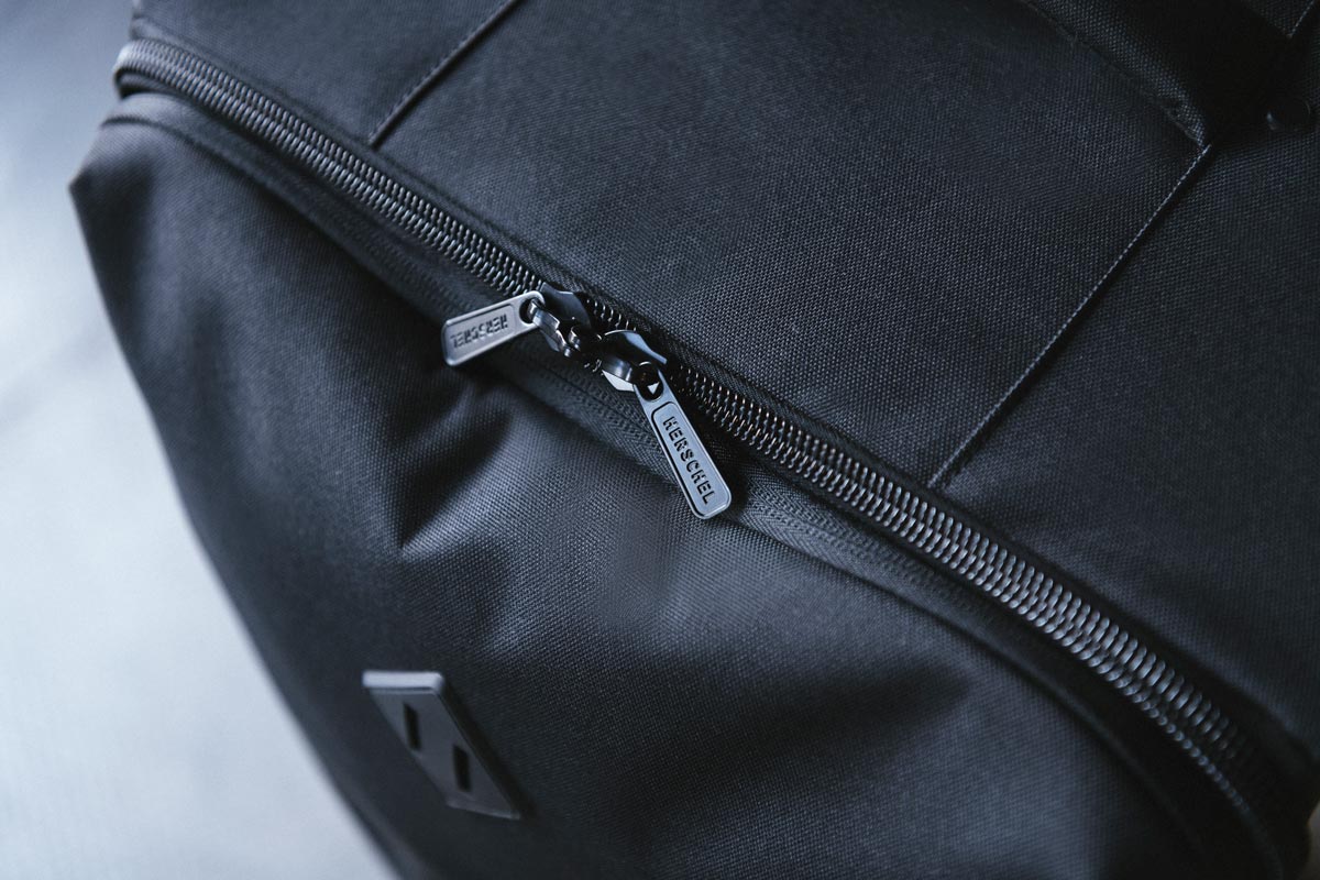 A shot of the zippered closure on the Highland Luggage Large with its branded lockable zipper pulls